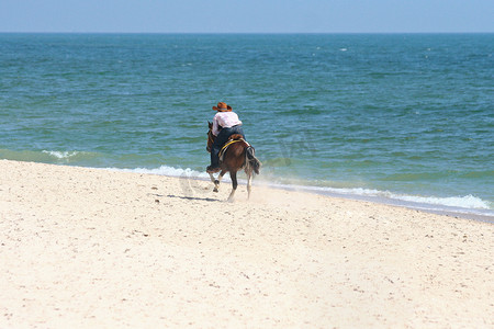 一个人骑马在沙滩上奔跑