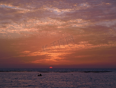 日落时单人皮划艇的海景