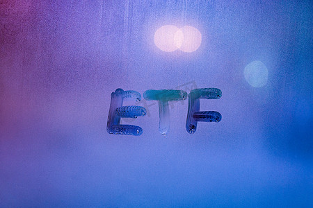 缩写词 etf — 交易所交易基金 — 夜间在雾蒙蒙的玻璃窗上手写，霓虹蓝后路灯