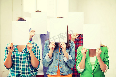 国际模板摄影照片_学生用白纸遮住脸