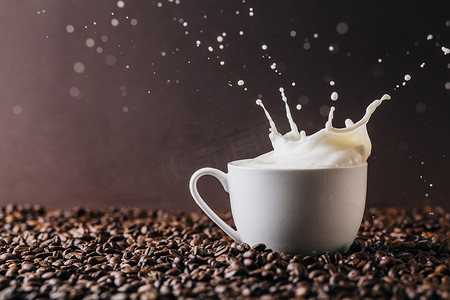 早上喝牛奶摄影照片_牛奶飞溅在咖啡豆上
