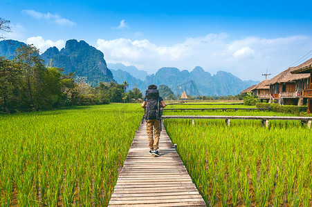 王维田园乐摄影照片_背着背包走在老挝万荣木路上的旅游