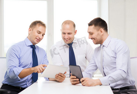 三个面带微笑的商人在办公室使用平板电脑