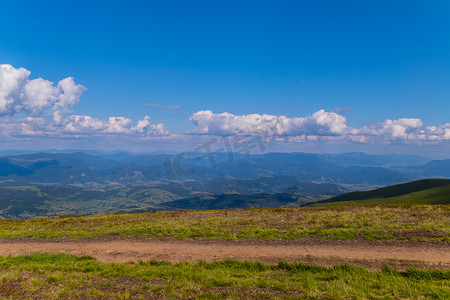 巨大的平缓倾斜的绿色山脉和无边无际的蓝色天空的顶视图