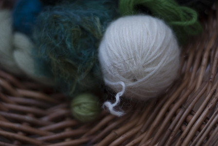 篮子编织上柔软的绿色和白色羊毛特写