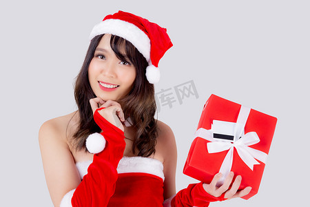 美丽的肖像年轻亚洲女人兴奋地拿着红色礼盒，在圣诞节假期里有卡片或标签，与白色背景隔离，亚洲女孩惊喜，并在节日的圣诞节和新年庆祝。