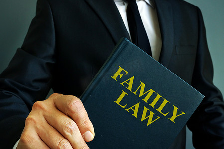 协议离婚摄影照片_关于男人手中离婚的家庭法书籍。