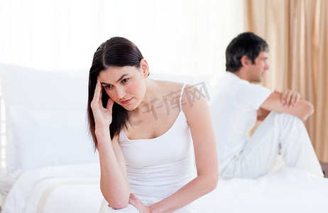 生气的夫妻坐在床上吵架