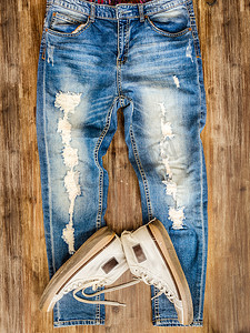 木材纹理上复古风化牛仔裤和鞋子的细节