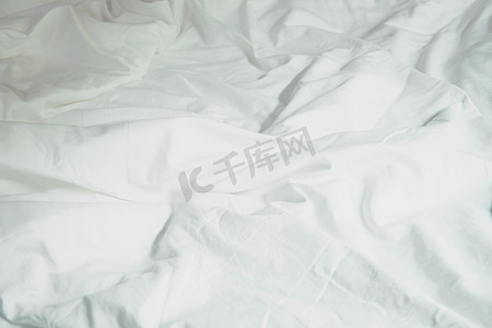 床和被子摄影照片_床上的白色枕头和卧室里皱巴巴的凌乱毯子，F
