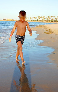 小男孩海边摄影照片_海边沙滩上的小男孩