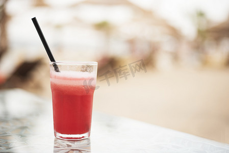 西瓜大海摄影照片_红色鸡尾酒，桌上新鲜的西瓜，特写。
