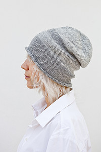 戴着温暖的灰色无檐小便帽羊毛针织帽的女人。