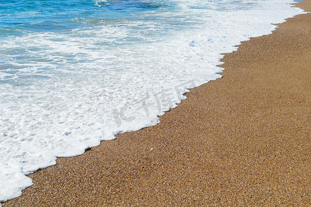 温柔的阳光摄影照片_温柔的海浪拍打着智利安托法加斯塔的海滩。