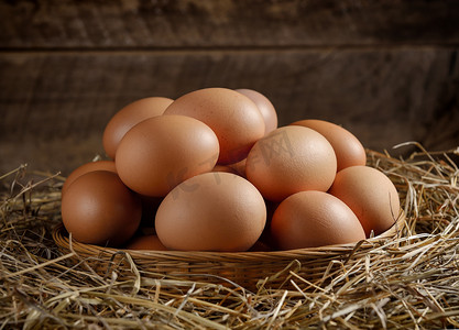 鸡蛋加工摄影照片_干草上篮子里的鸡蛋