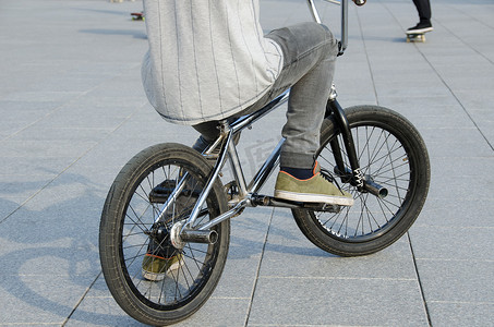 骑自行的男孩摄影照片_穿运动服的家伙坐在运动 BMX 自行车上