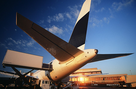 飞机夕阳摄影照片_飞机尾翼在机场日落的
