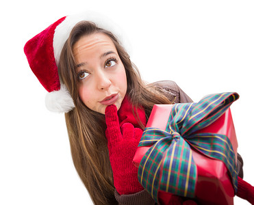 有想法的女孩戴着圣诞圣诞帽，蝴蝶结包裹着礼物，与白色隔离
