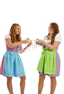 两个巴伐利亚打扮的女孩拉着小牛肉香肠
