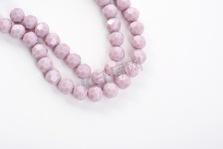 翡翠手镯摄影照片_白色背景上美丽的浅紫色玻璃闪光水晶 Isoalted 珠。