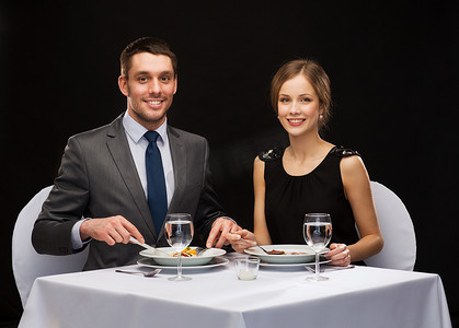 微笑的夫妇在餐厅吃主菜