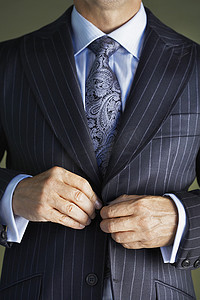 一位穿着西装的商人在外套上扣扣的特写中段
