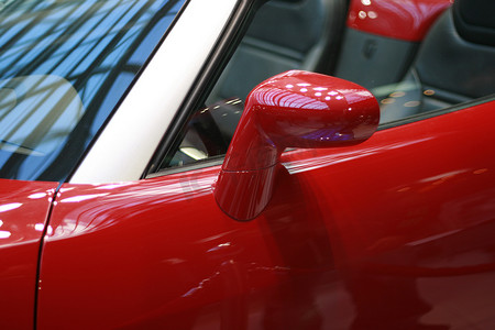 闪亮的红色汽车的左侧镜子