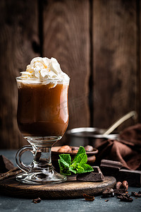 圣诞节深色摄影照片_冰可可饮料加鲜奶油、冷巧克力饮料、深色背景中的咖啡冰沙