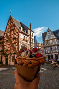 德国美因茨手拿冰淇淋，德国美因茨市中心的古典木屋