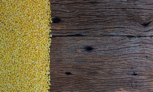 大豆玉米摄影照片_在木头背景的被剥皮的分裂大豆。