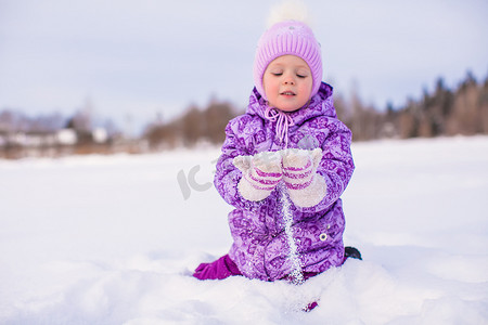 阳光明媚的衣服摄影照片_快乐的小女孩在冬天阳光明媚的日子里玩雪