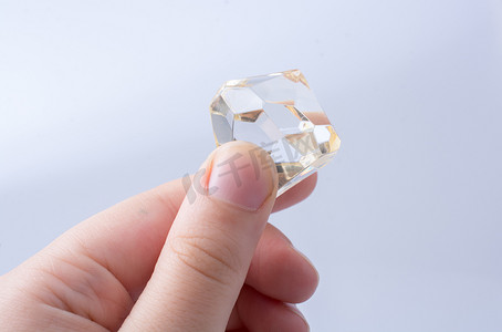 价格透明摄影照片_手拿着白色背景上的透明钻石