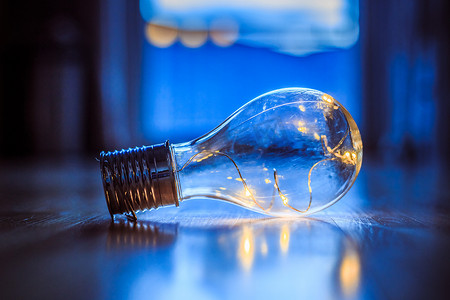 想法和创新：带 LED 的灯泡躺在木地板上。
