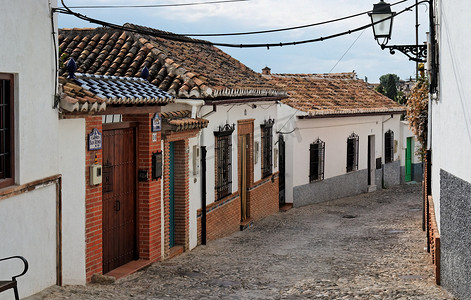 弯曲泼墨摄影照片_“西班牙格拉纳达的小弯曲街道”