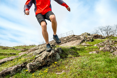 奔跑的运动员摄影照片_在落基山小径上奔跑的运动员腿部特写。