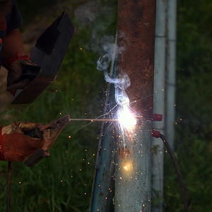 带手套和焊接面罩的男焊工用焊接焊接