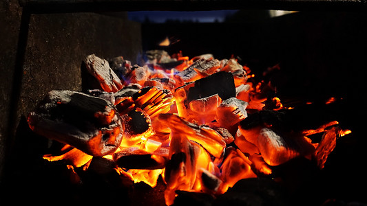 篝火摄影照片_炭火壁炉格栅火焰，黑色背景