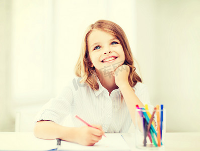 微笑的小学生女孩在学校画画