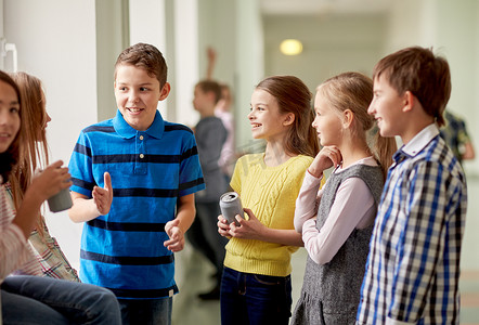 初等摄影照片_走廊里拿着汽水罐的一群学童