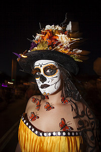 女人在 Dia De Los Muertos 化妆与蝴蝶