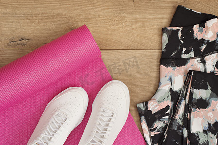 粉色瑜伽垫、女性运动鞋、运动鞋、平躺式紧身裤、顶视图。