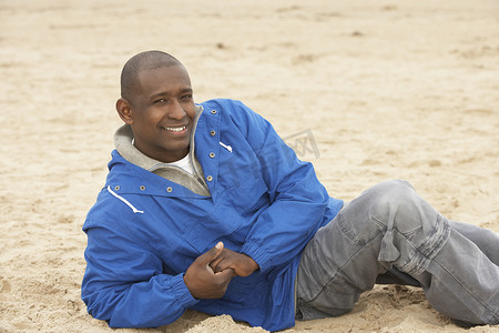 男人穿着秋装在海滩上放松