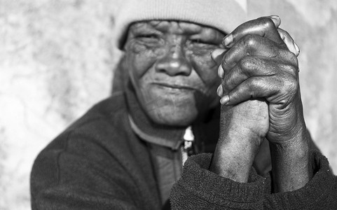 一位非洲老年妇女双手合十的黑白照片 — 关注风化的手