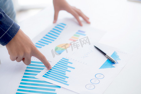 年轻商人的手指向文档数据图表和图表纸、营销和投资、财务、经济和财务增长、管理和规划的统计利润报告。
