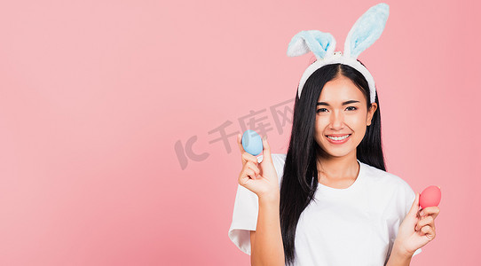 戴着兔耳微笑的女人手上拿着彩色复活节彩蛋礼物