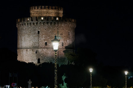 塞萨洛尼基希腊白塔的夜景，周围有圣诞灯饰。