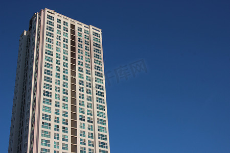 城市建筑商务背景摄影照片_晴天蓝天的摩天大楼商业大楼的广角视图。