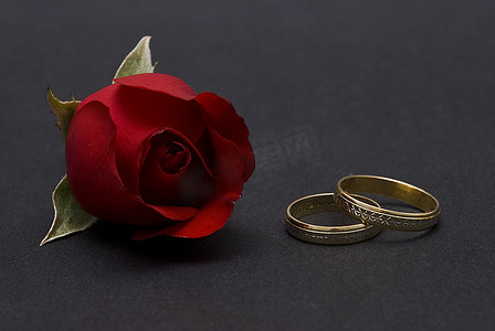 结婚戒指和黑色的红玫瑰。