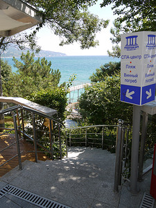 指示图标摄影照片_通往大海的楼梯和附近的指示器，指示水疗中心所在的位置，酒窖的海滩