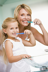 浴室儿童摄影照片_女人和年轻女孩在浴室刷牙